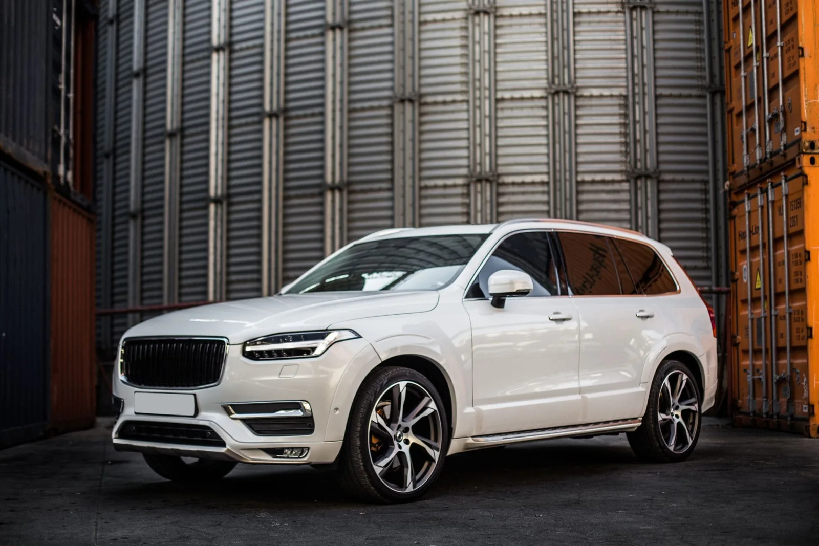 SUV blanco con ventanas tintadas frente a una fachada moderna